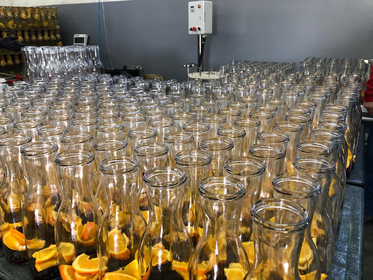 Glass bottles filled with fresh orange slices at the Fruite Voyage facility